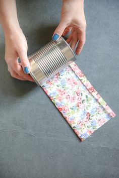 a woman is holding a can opener over a flowered napkin