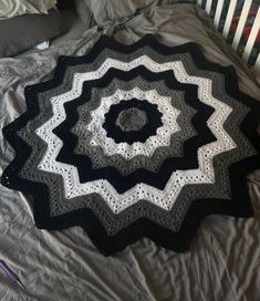 a black and white crocheted blanket on top of a bed