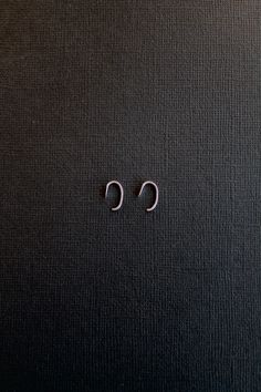 the word o is written in cursive silver on a black background with two circles