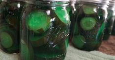 several jars filled with pickles and cucumbers