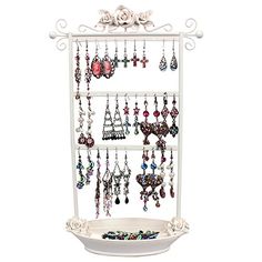 a white jewelry rack with earrings hanging from it's sides and an earring holder in the middle