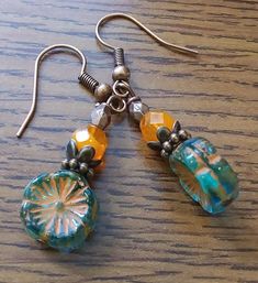 Teal blue flower drop Czech glass Picasso earrings that resemble a Hibiscus flower with orange inlays Details: 12mm teal blue transparent flower Czech glass bead with orange inlays and edges 6mm faceted 2 tone orange  Czech beads 4.3mm antique copper faceted oval beads  6mm antique copper daisy spacer bead 6mm Tibetan Style Brass Bead Cap Antique copper nickel free fishhook ear wires Czech Glass Beads Jewelry, Unique Beaded Earrings With Czech Glass, Handmade Glass Bohemian Earrings, Blue Teardrop Bohemian Flower Earrings, Bohemian Teardrop Glass Earrings, Bohemian Czech Glass Beaded Earrings, Blue Bohemian Teardrop Flower Earrings, Bohemian Glass Drop Earrings, Bohemian Blue Teardrop Flower Earrings