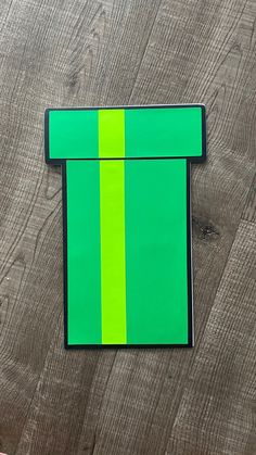 a piece of paper with a green and yellow stripe on it sitting on top of a wooden table