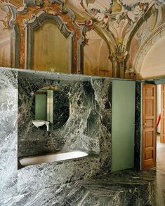 a bathroom with marble walls and flooring in an ornate style, including a bathtub