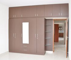 an empty room with brown cabinets and white flooring in the center is a closet