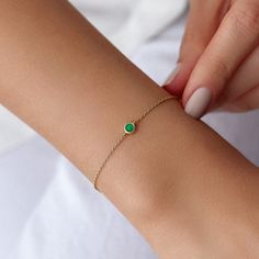 Our simple and elegant solitaire bracelet features a round cut natural emerald at its center. We can craft this bracelet in 14K or 18K Gold according to your preference.★ Bracelet Features• Gold Kt: 14K/18K Solid Gold (All pieces are stamped for authenticity)• Available Gold Colors: Yellow Gold, Rose Gold, White Gold• Center Round Cut Emerald Weight: 0.12 carat• We only work with real natural emeralds• We offer a signed certificate with each bracelet for the authenticity of the center emerald st Minimalist Green Bracelet, Dainty May Birthstone Bracelets, Green Minimalist Bracelet With Jubilee Design, Dainty May Birthstone Bracelet, Green Round Birthstone Bracelet, Green Gemstone Gold Bracelet, Minimalist Yellow Gold Bracelet For May Birthstone, Round Emerald Bracelets For Gifts, Classic Bracelets With May Birthstone