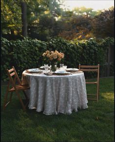 the table is set for two outside in the grass