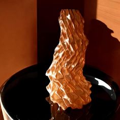 a glass sculpture sitting on top of a black plate