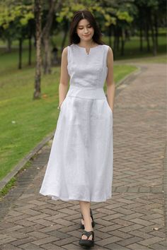 Keep it fresh and fashionable this summer with our Linen Midi Dress. This sleeveless, split neck white dress, perfectly designed for those hot summer days, ensures you stay comfortable while looking chic.  ★★FEATURES 100% Linen Two side pockets White cotton lining Split V neck dress Right hidden zipper Sleeveless Linen dress Linen midi dress Below knee length Minimalist Dress Perfect for summer,spring Other more color selection ★★ Bespoke Order Service If you Request other color Request the length Your height is not between 155 cm- 172 cm Your weight is over 75 kg I can do it for you, It will need some extra fee depending on on your need. Contact with me for more detail. ★★ Get your size in Size Chart with your body measurement https://www.etsy.com/listing/794055682 ★★ Warmly Note: 1 ) : P White Dress Summer Casual, Simple Cotton Dress, Simple Linen Dress, Sleeveless White Dress, Knee Length Dresses Casual, White Casual Dress, Simple White Dress, White Linen Dress, Minimalist Dress