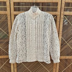 CROSS POSTED and in person at my Vintage Booth.  A prompt refund will be given if item has already been sold.  Thank you for understanding.  Lovely vintage cream lace blouse with high ruffle collar, box pleats and blouson sleeves!  Has a Victorian vibe. Great piece for layering or wearing alone with faded denim.  DETAILS: Good condition 1970s Era Feels like polyester lace Cream/off white shade Ruffle collar Box pleat details down front with hidden buttons Blouson sleeves with button cuff Straight hem  Washed, ready to wear FLAWS: **a hint of gray at edges on cuffs, neck but no one would notice **has a perfume scent, I washed but it is still there LABEL:  None  MEASUREMENTS while flat: Shoulder:  15" Sleeves:  22" Bust:  36" Waist:  33" Hips:  36" Length:  24" MODERN FIT SIZE:  SMALL TO MED Vintage Booth, Faded Denim, Ruffle Collar, 70s Vintage, Vintage Victorian, Denim Details, Cream Lace, Lace Ruffle, Box Pleats