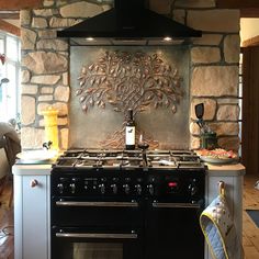 a stove top oven sitting inside of a kitchen next to a stone wall mounted oven