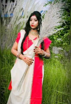 a woman standing in front of some tall grass