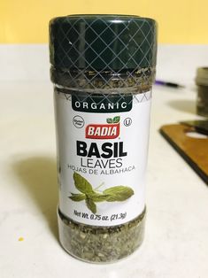 a jar of basil leaves sitting on top of a counter