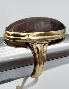 This is a 14k yellow gold ring set with a 26mm by 12mm oval smoky quartz. The ring is a size 6 and weighs 5.5 dwt. The quartz has color and pattern variations that did not show up very well in the pictures. Classic Smoky Quartz Rings For Formal Occasions, Classic Oval Brown Ring, Classic Brown Oval Ring, Classic Formal Smoky Quartz Rings, Brown Oval Gemstone Rings, Brown Oval Cabochon Rings, Luxury Brown Oval Rings, Formal Brown Cabochon Rings, Smoky Quartz Ring