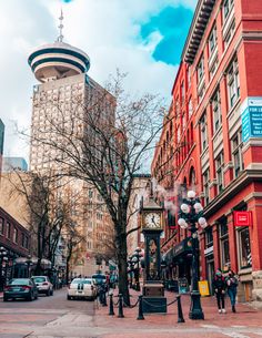 people are walking on the street in front of tall buildings and trees with no leaves