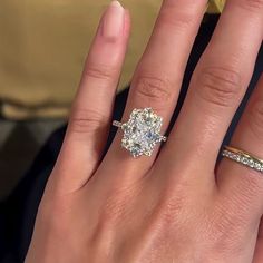 a close up of a person's hand with an engagement ring