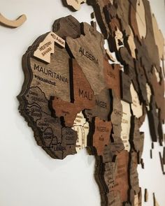 a wooden map of the world hanging on a wall