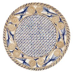 a blue and white plate with some flowers on it's rim, against a white background