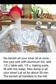 a person pouring water into a metal pan with foil on the bottom and red spoon in it