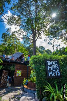 there is a sign that says three more keys in front of some trees and bushes