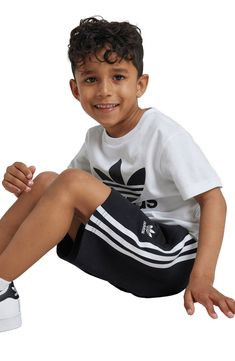 A bold Trefoil design dominates a kid-sized T-shirt that's paired with matching shorts finished with signature 3-Stripes racing down the sides. Shorts have elastic/drawstring waist; side-seam pockets 70% cotton, 30% recycled polyester Machine wash, tumble dry Imported Adidas Casual Tops For Playwear, Casual Adidas Tops For Playwear, White Cotton Shorts With Three Stripes, Adidas Cotton Shorts With Three Stripes, Adidas Cotton Shorts With Three Stripes Branding, White Cotton Adidas Shorts, Adidas Short Sleeve T-shirt With Three Stripes, Adidas Athletic Shorts With Built-in Shorts For Streetwear, Adidas Shorts With Built-in Shorts For Sports