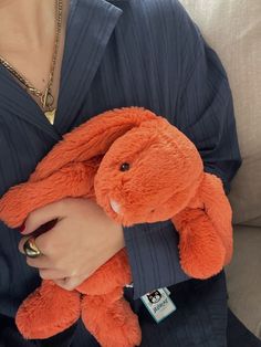 a woman holding an orange stuffed animal in her lap