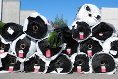 many rolls of black and white paper are stacked on top of each other in front of a building