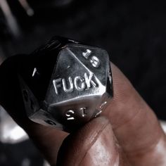 a close up of a person holding a metal dice