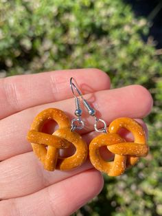 these pretzel earrings are too cute not to wear! the handmade earrings are a perfect gift for your friends, kids, or yourself!! Earrings are sterling silver! Hypoallergenic and 925 stamped! Please note:polymer clay charms are durable, but still need to be handled with care (: These clay charms are hand made and are not perfect! They may vary from the one in the picture but still just as cute!Colors may not be the exact same shade as the photo due to the lighting. All charms are individually pack Weird Clay Earrings, Funny Clay Earrings, Polymer Clay Charm Ideas, Easy Polymer Clay Earrings, Clay Earrings Ideas, Pretzel Earrings, Fun Earrings Unique, Polymer Clay Earrings Diy, Clay Earrings Cute