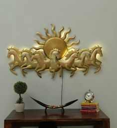 a wooden table topped with a vase filled with flowers next to a wall mounted clock