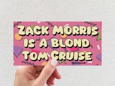 someone holding up a sticker that says, zac morris is a blond tom cruise