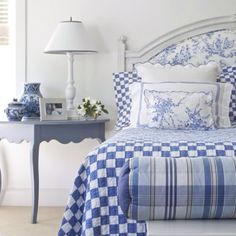 a bed with blue and white checkered bedspread in a bedroom next to a window