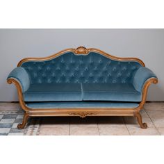 a blue couch sitting on top of a tiled floor