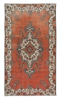 an orange and black rug with ornate designs on it's border, in the middle of