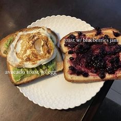 toast with blueberries jam and an egg on it sitting on top of a white plate