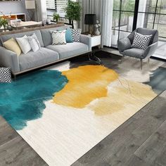 a living room with couches, chairs and rugs on the hardwood flooring