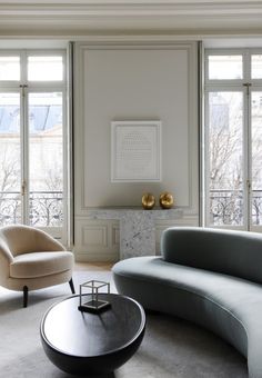 a living room filled with furniture and large windows