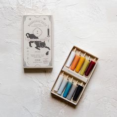 an open box with different colored crayons in it