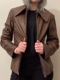 Chocolate Brown Genuine Leather Jacket with large front pockets and oversized lapel. Nickel colored finishings, hip length fit. 17 inches from shoulder to shoulder, 26 1/2 inches from collar to tail. Minor imperfections on left sleeve and front scratch as pictured. Retro Notch Lapel Outerwear For Fall, Retro Outerwear With Pockets For Office, Vintage Outerwear With Suit Collar For Fall, Vintage Fall Outerwear With Suit Collar, Fitted Leather Jacket With Lapel Collar For Fall, Vintage Leather Jacket With Lapel Collar For Fall, Retro Business Outerwear With Lapel Collar, Retro Formal Fall Outerwear, Retro Formal Outerwear With Lapel Collar