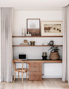 a room with a desk, chair and pictures on the wall