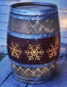 a wooden barrel with snowflakes on it sitting in the middle of a yard