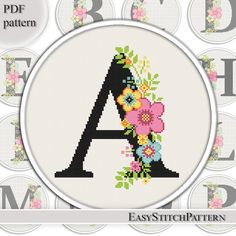 a cross stitch pattern with the letter a in it's center and flowers on top