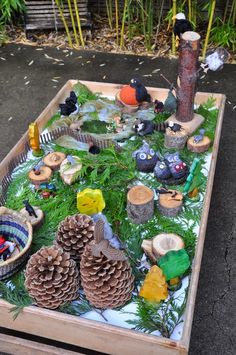 a wooden table topped with lots of different types of toys and trees on top of it