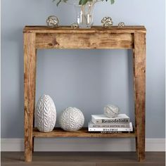 a wooden table with two white vases on top of it next to a book shelf