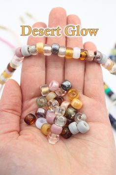 a hand holding several different colored beads in it's palm with the words desert glow written above them