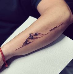 a person with a mountain tattoo on their arm