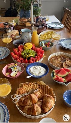 a wooden table topped with lots of plates and bowls filled with different types of food