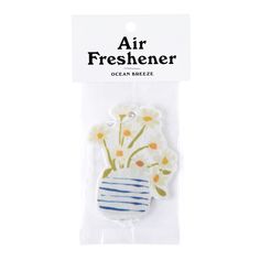 an air freshener with flowers in a blue and white striped vase on the front