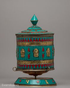 an ornate teal and gold box on a stand