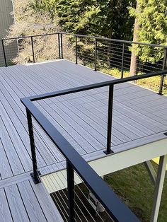 an outdoor deck with railings and trees in the background